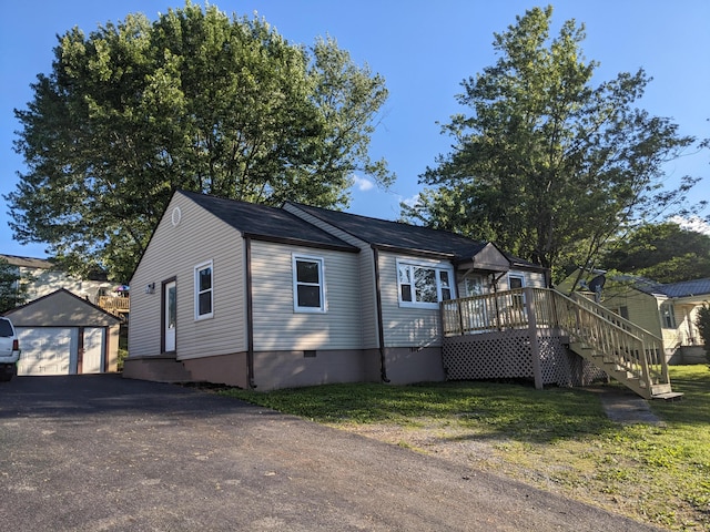 view of front of home with an outdoor structure, a deck, driveway, crawl space, and a garage