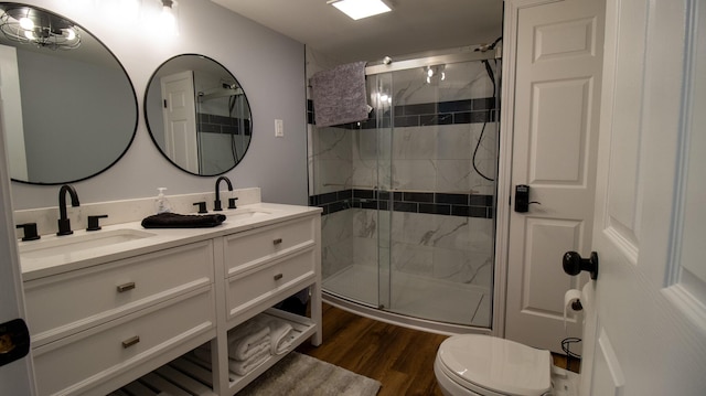 bathroom featuring a stall shower, wood finished floors, and a sink