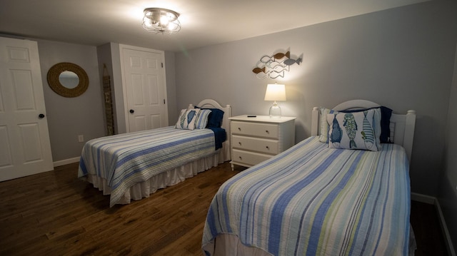 bedroom with dark wood-type flooring and baseboards