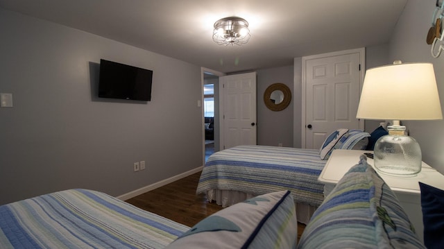 bedroom featuring baseboards and wood finished floors