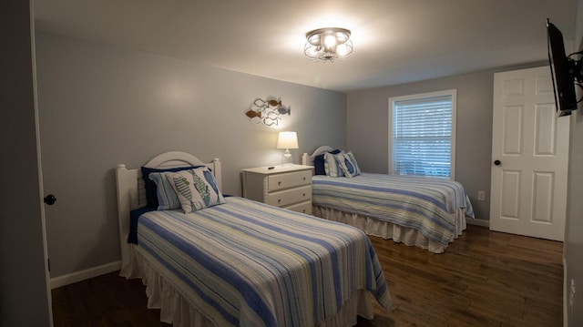 bedroom with dark wood-type flooring and baseboards