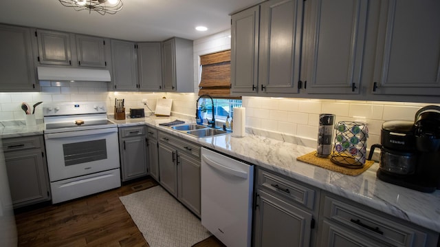 kitchen with under cabinet range hood, white appliances, gray cabinetry, and a sink