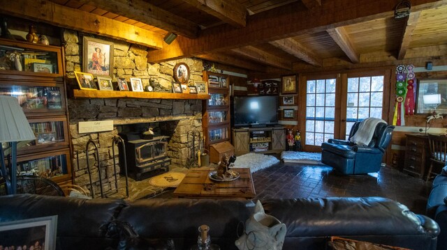 living room with beam ceiling, wood ceiling, and a wood stove