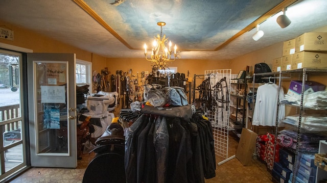 miscellaneous room featuring a notable chandelier, plenty of natural light, and a textured ceiling