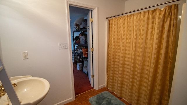 bathroom with parquet floors, sink, and walk in shower