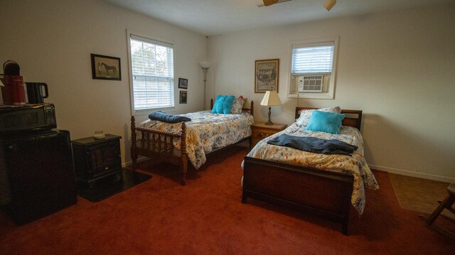 bedroom featuring a wood stove, ceiling fan, and dark carpet