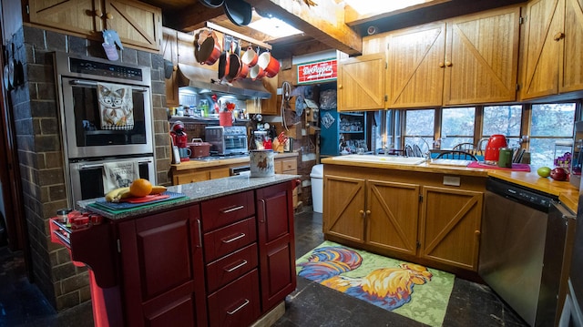 kitchen featuring beamed ceiling, sink, and stainless steel appliances