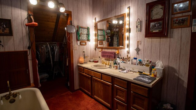 bathroom featuring wooden walls, a washtub, and vanity