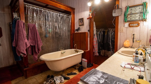 bathroom with a tub to relax in, vanity, and parquet floors