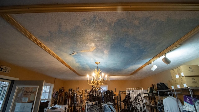 room details with a textured ceiling, track lighting, and a notable chandelier