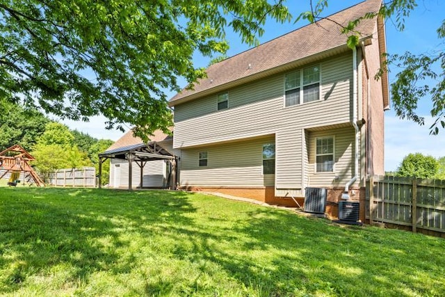 back of house featuring central air condition unit, a gazebo, fence, and a lawn