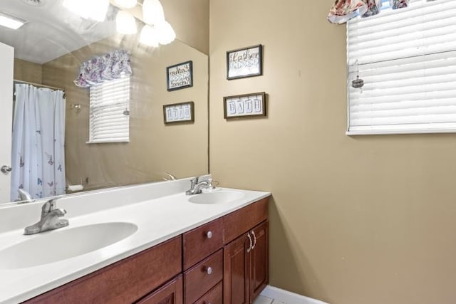 full bath with double vanity, a sink, and curtained shower