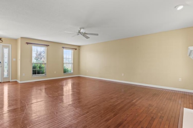 empty room with baseboards, ceiling fan, and wood-type flooring