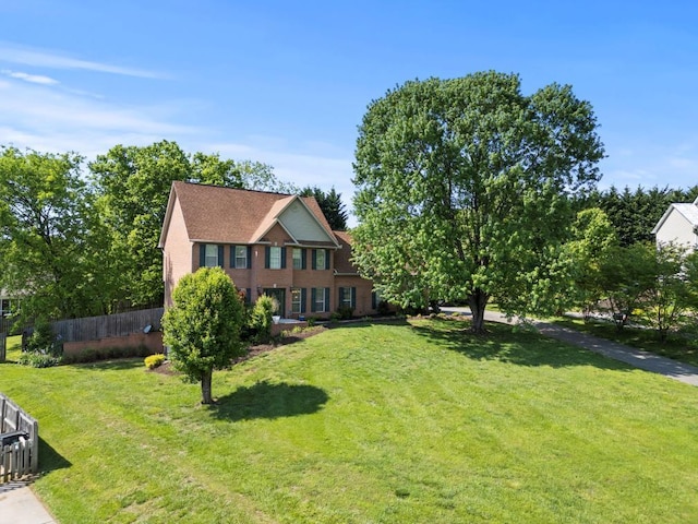 view of front of home with a front lawn and fence