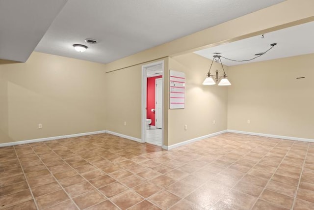 unfurnished room featuring baseboards and visible vents