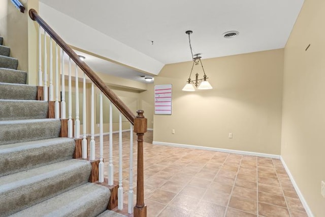 stairway featuring baseboards, lofted ceiling, and tile patterned flooring