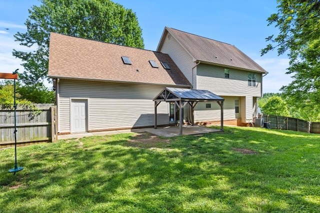 back of house featuring a lawn, central air condition unit, a shingled roof, a fenced backyard, and a patio area