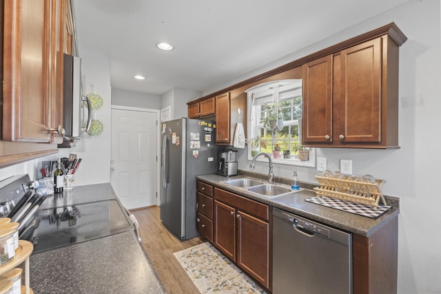 411 Mckinney Dr, Sevierville, TN 37876 - kitchen featuring a sink, stainless steel appliances, recessed lighting, dark countertops, and light wood-style floors