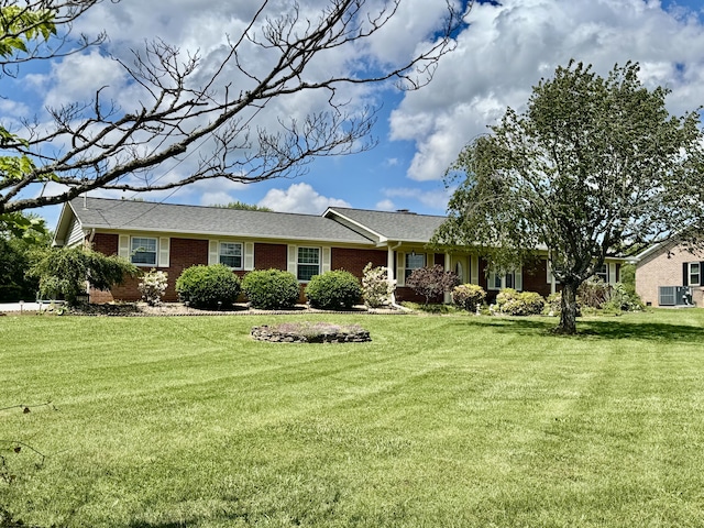 ranch-style home with brick siding, central AC unit, and a front lawn