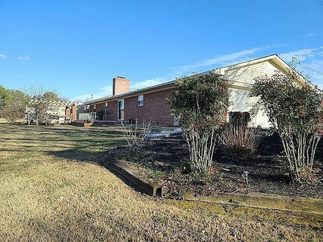 view of home's exterior featuring a chimney and a yard