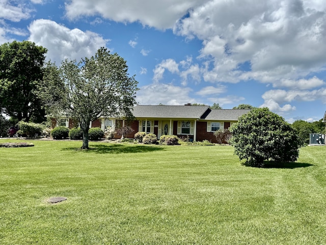 view of front of house featuring a front lawn and brick siding