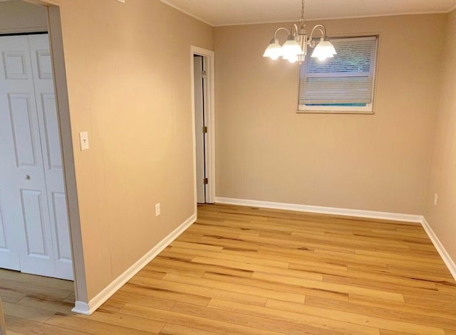 unfurnished dining area featuring light wood-type flooring and an inviting chandelier