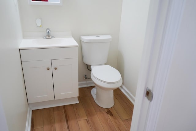 bathroom with vanity, toilet, and wood-type flooring