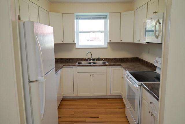 kitchen with white cabinets, white appliances, and sink