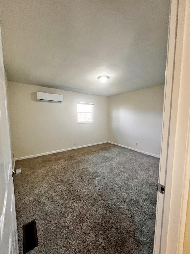 unfurnished room with dark carpet and an AC wall unit