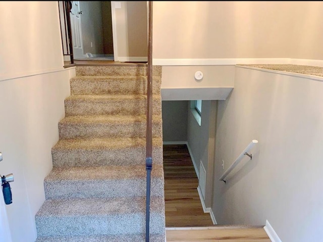 stairway with hardwood / wood-style floors