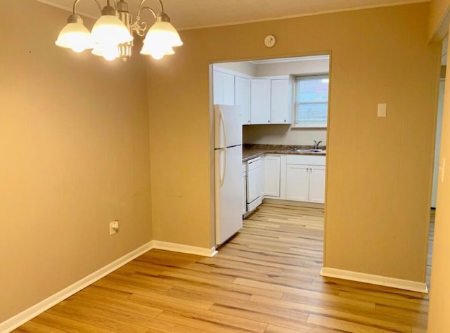 kitchen featuring white cabinetry, light hardwood / wood-style flooring, a notable chandelier, white appliances, and decorative light fixtures