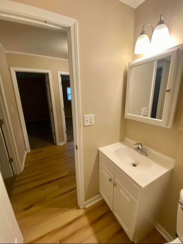 bathroom with vanity, toilet, and wood-type flooring