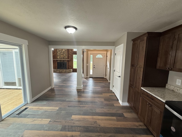 2157 Windy Cove Ln, Talbott, TN 37877 - kitchen featuring electric range, dark wood-style floors, a textured ceiling, a fireplace, and dark brown cabinets
