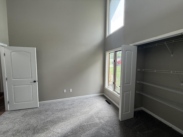 2157 Windy Cove Ln, Talbott, TN 37877 - unfurnished bedroom featuring dark carpet, multiple windows, and a towering ceiling