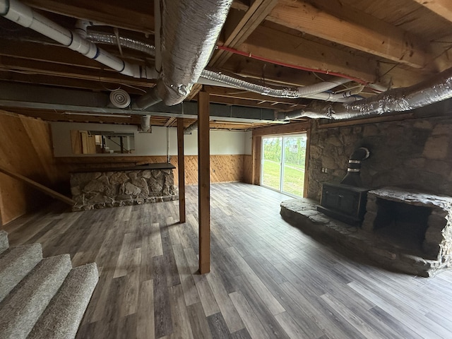 2157 Windy Cove Ln, Talbott, TN 37877 - below grade area featuring a wood stove, wooden walls, wood finished floors, and a wainscoted wall