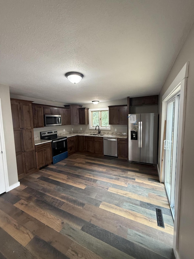 2157 Windy Cove Ln, Talbott, TN 37877 - kitchen with appliances with stainless steel finishes, dark wood-type flooring, light countertops, dark brown cabinetry, and a textured ceiling