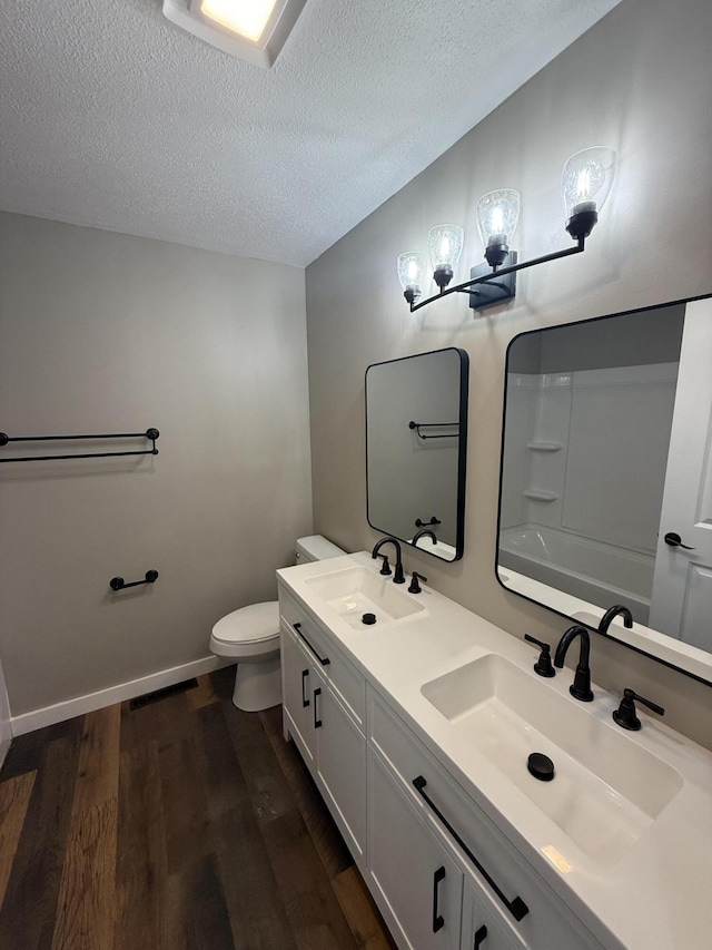 2157 Windy Cove Ln, Talbott, TN 37877 - bathroom featuring wood finished floors, double vanity, and a textured ceiling
