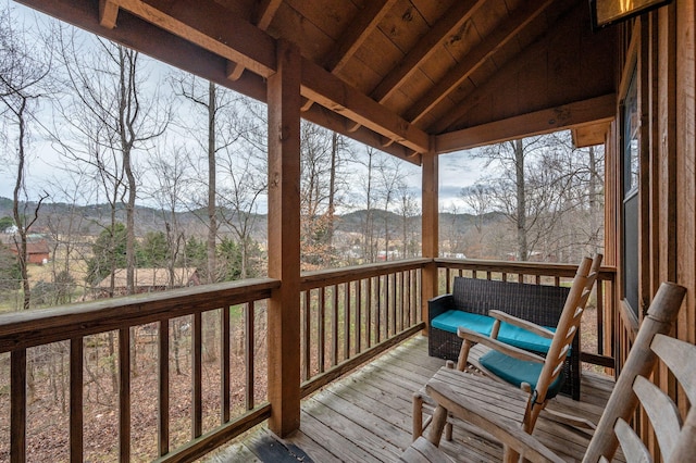 wooden terrace featuring a mountain view and an outdoor hangout area