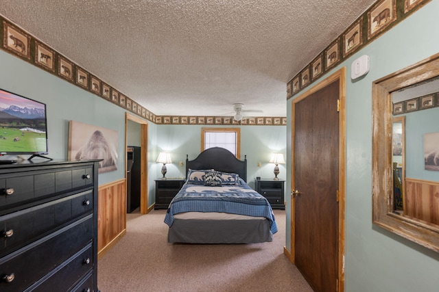 bedroom featuring carpet floors, wooden walls, and a textured ceiling