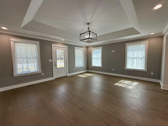 foyer with crown molding, a tray ceiling, and dark wood-style flooring