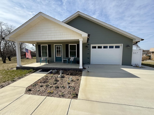 view of front of property featuring a garage, concrete driveway, and a porch