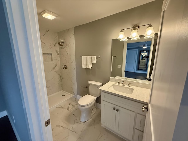 bathroom featuring marble finish floor, a marble finish shower, toilet, vanity, and baseboards