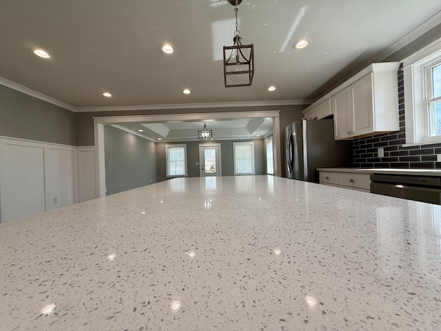 kitchen with tasteful backsplash, white cabinets, stainless steel appliances, crown molding, and recessed lighting