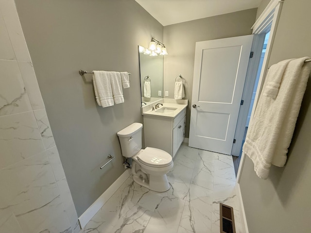 bathroom featuring toilet, vanity, visible vents, baseboards, and marble finish floor