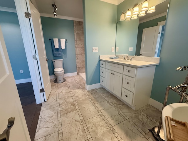 full bath featuring toilet, a tile shower, vanity, and baseboards