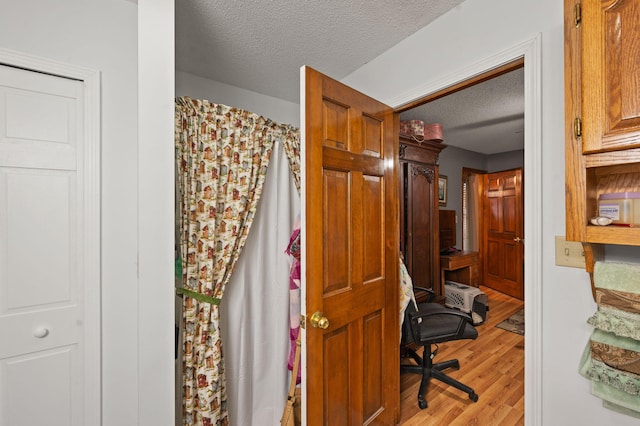 bathroom with wood finished floors and a textured ceiling