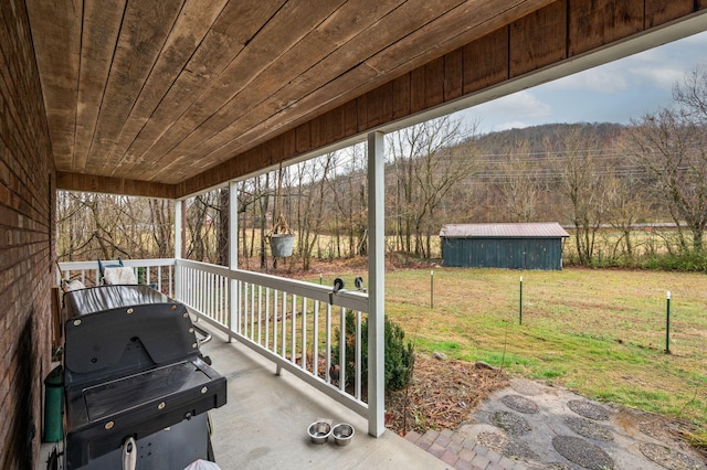 view of patio with grilling area, a view of trees, and a mountain view