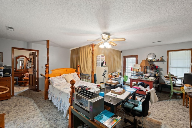 carpeted bedroom featuring a ceiling fan, a textured ceiling, and visible vents