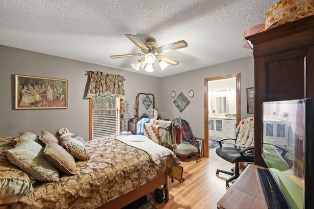 bedroom with connected bathroom, ceiling fan, a textured ceiling, and light wood finished floors