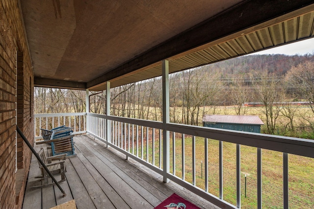 deck featuring a forest view and a yard